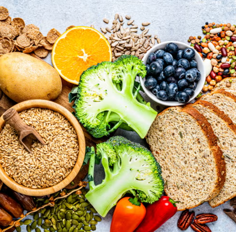 Grocery basket containing beans, lentils, oats, vegetables, fruit, nuts, and whole grains